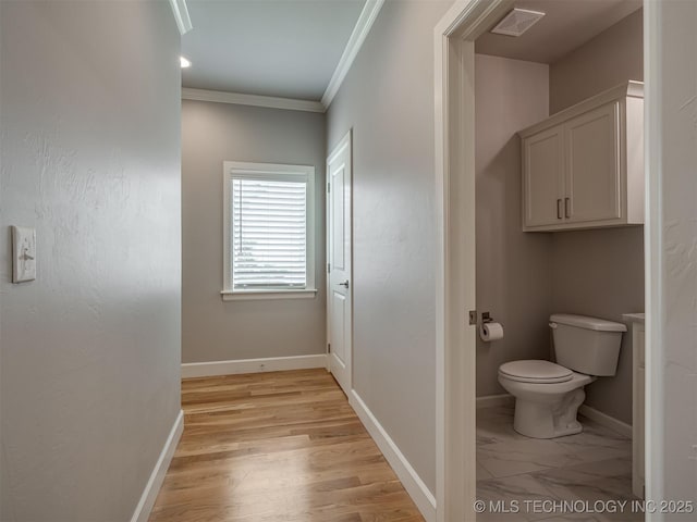 bathroom featuring visible vents, crown molding, baseboards, toilet, and wood finished floors
