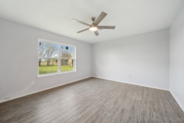 empty room featuring a ceiling fan, baseboards, and wood finished floors