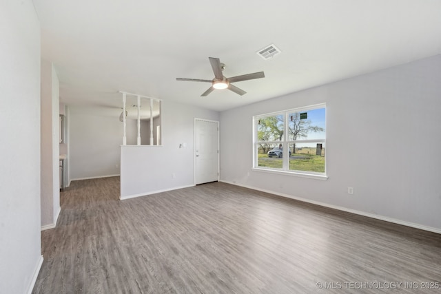unfurnished room featuring baseboards, ceiling fan, visible vents, and wood finished floors