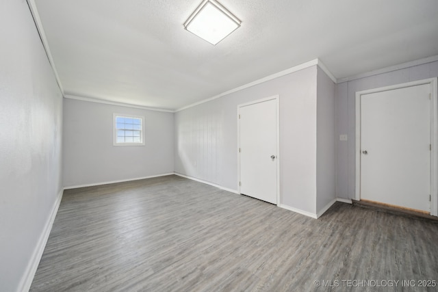 interior space with baseboards, ornamental molding, and wood finished floors
