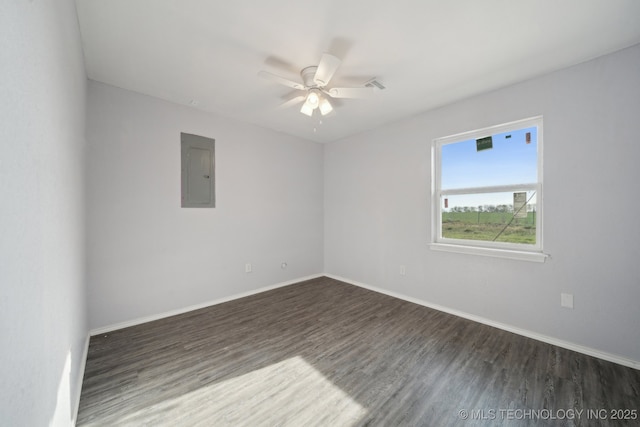 spare room with electric panel, dark wood-style floors, ceiling fan, and baseboards