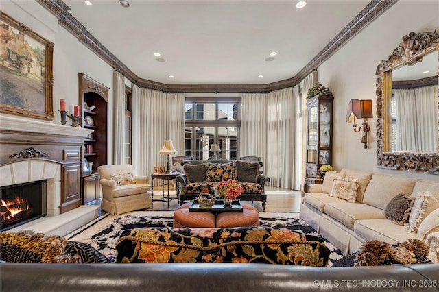 living room featuring recessed lighting, crown molding, and a premium fireplace