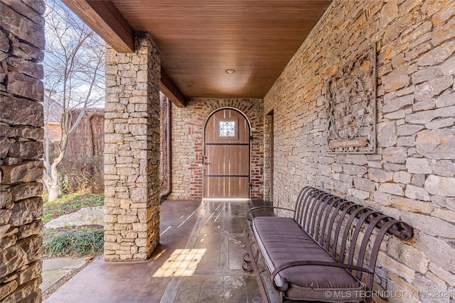 property entrance with a porch and stone siding