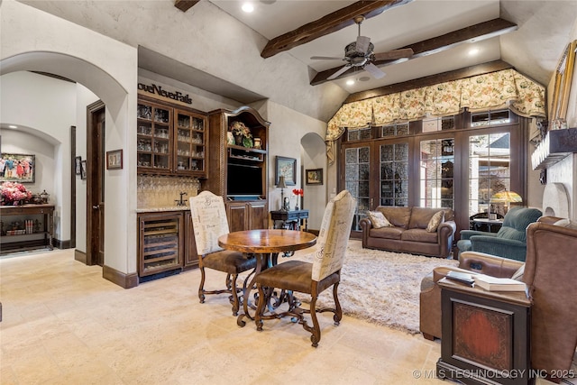 wine area featuring ceiling fan, wine cooler, arched walkways, and bar