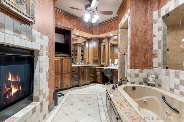 bathroom with a glass covered fireplace, a jetted tub, a ceiling fan, and ornamental molding