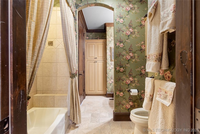 full bathroom featuring wallpapered walls, toilet, shower / tub combo with curtain, crown molding, and baseboards