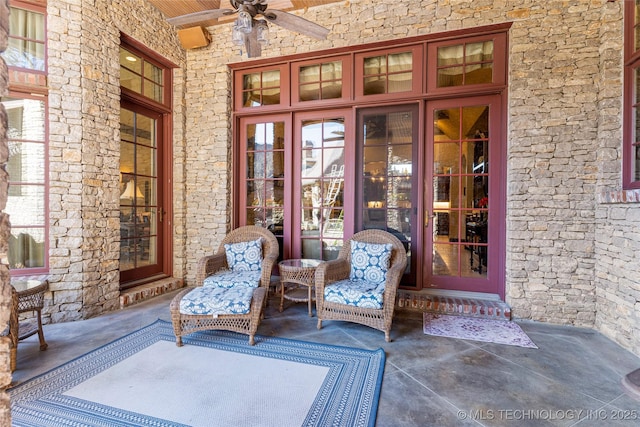 view of exterior entry with stone siding and ceiling fan