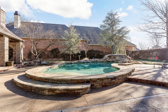 view of swimming pool with a hot tub and a patio