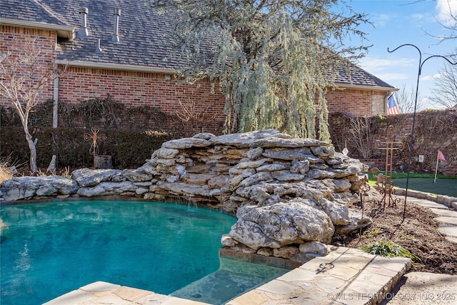 view of swimming pool with a swimming pool and fence
