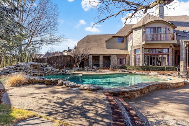 view of swimming pool featuring a pool, fence, and a patio area