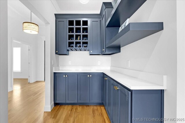 12202 S 102 E Ave, Bixby, OK 74008 - kitchen with light countertops, open shelves, hanging light fixtures, light wood-type flooring, and blue cabinetry