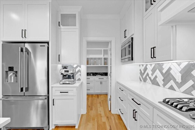 12202 S 102 E Ave, Bixby, OK 74008 - kitchen with white cabinetry, light countertops, stainless steel appliances, decorative backsplash, and glass insert cabinets