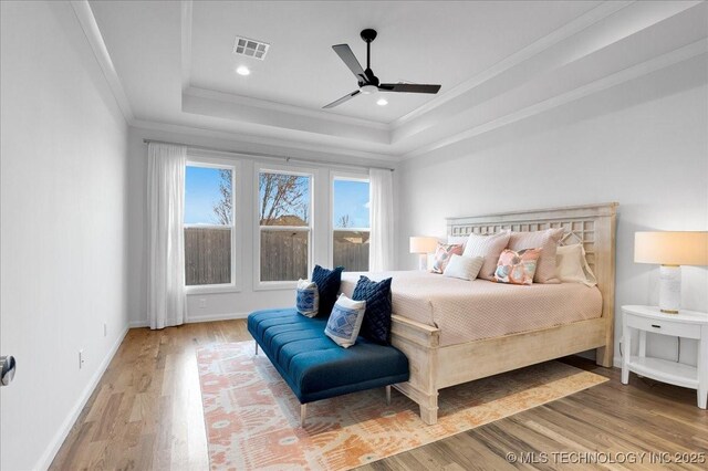 12202 S 102 E Ave, Bixby, OK 74008 - bedroom featuring crown molding, a raised ceiling, wood finished floors, baseboards, and visible vents