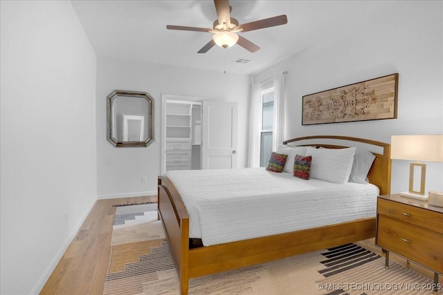 12202 S 102 E Ave, Bixby, OK 74008 - bedroom featuring wood finished floors, a walk in closet, baseboards, visible vents, and ceiling fan