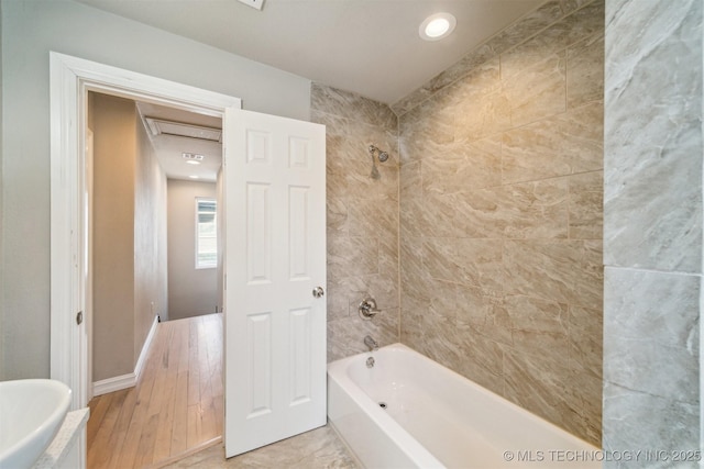 bathroom featuring bathtub / shower combination and baseboards
