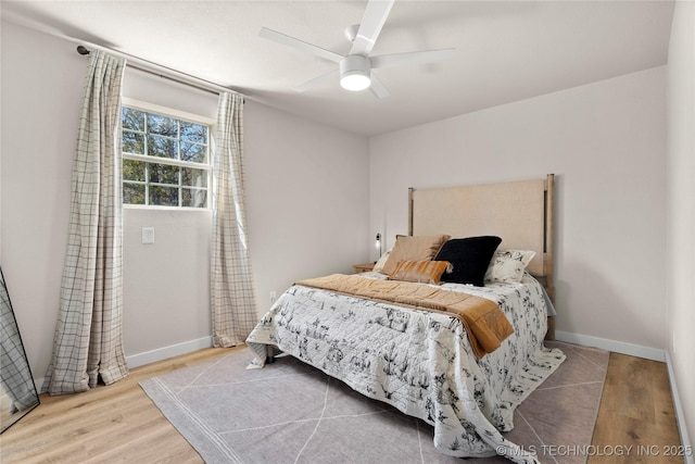 bedroom featuring baseboards, wood finished floors, and ceiling fan