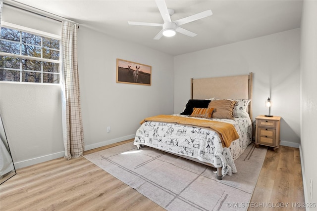 bedroom with baseboards, ceiling fan, and light wood finished floors