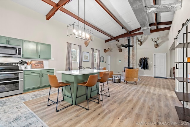 kitchen with green cabinetry, light countertops, beam ceiling, light wood-style flooring, and stainless steel appliances