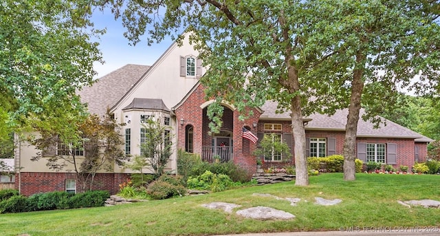 11748 S Canton Ave, Tulsa, OK 74137 - tudor-style house featuring brick siding, a front yard, and a shingled roof