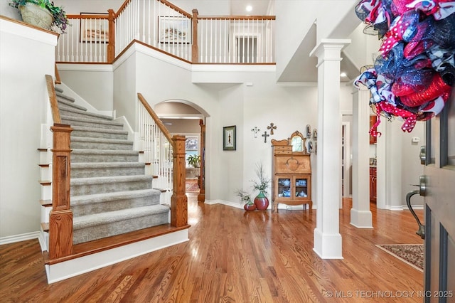 11748 S Canton Ave, Tulsa, OK 74137 - entryway featuring arched walkways, baseboards, a towering ceiling, and wood finished floors