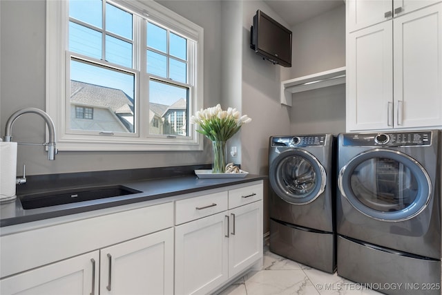 laundry room featuring a sink, washer and clothes dryer, cabinet space, and marble finish floor