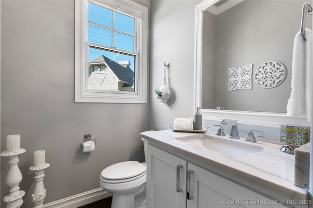 bathroom featuring vanity, baseboards, and toilet
