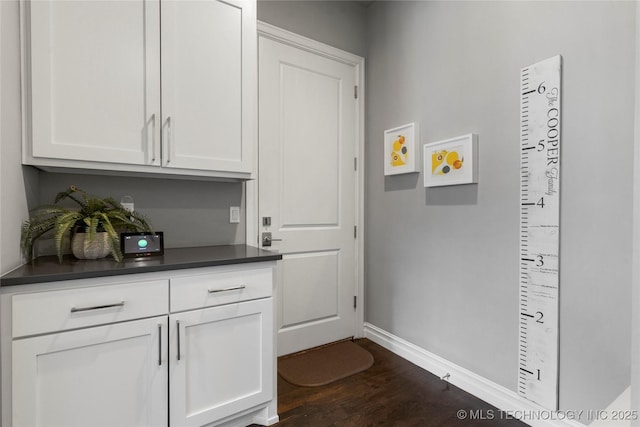 interior space featuring dark wood-type flooring and baseboards