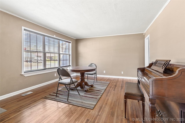 4641 S Trenton Ave, Tulsa, OK 74105 - dining room featuring crown molding, wood finished floors, a textured ceiling, baseboards, and visible vents