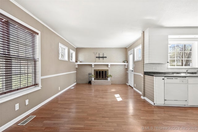 4641 S Trenton Ave, Tulsa, OK 74105 - kitchen featuring dishwasher, wood finished floors, a wealth of natural light, and visible vents