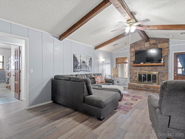 living room featuring a ceiling fan, plenty of natural light, and a textured ceiling
