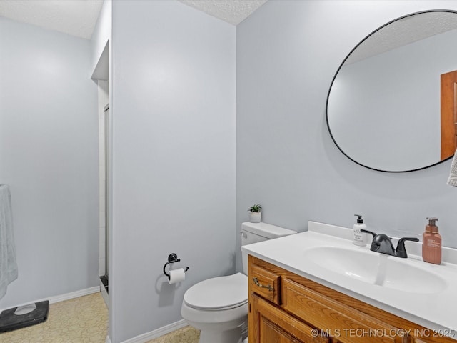 bathroom featuring toilet, vanity, a stall shower, and a textured ceiling