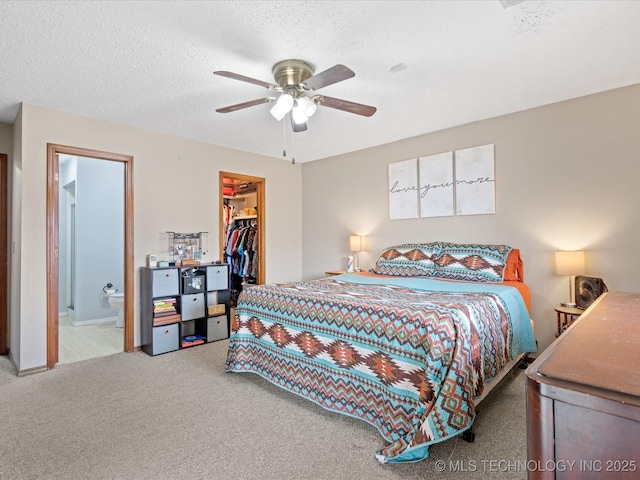 carpeted bedroom with a closet, a textured ceiling, connected bathroom, a ceiling fan, and a spacious closet