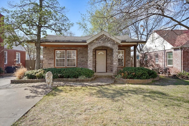 view of front facade featuring a front lawn and stone siding