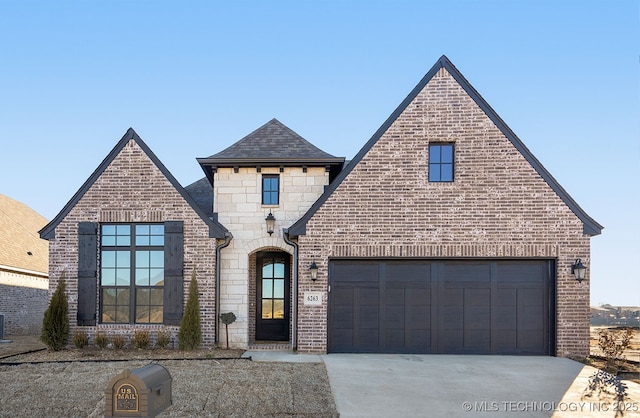french provincial home featuring cooling unit, brick siding, concrete driveway, and roof with shingles