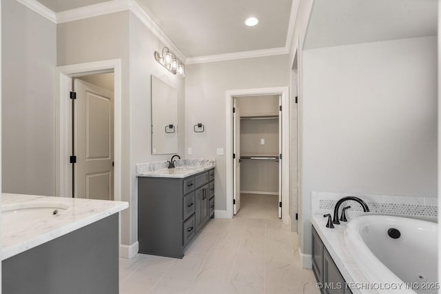 bathroom featuring baseboards, ornamental molding, two vanities, a jetted tub, and a walk in closet