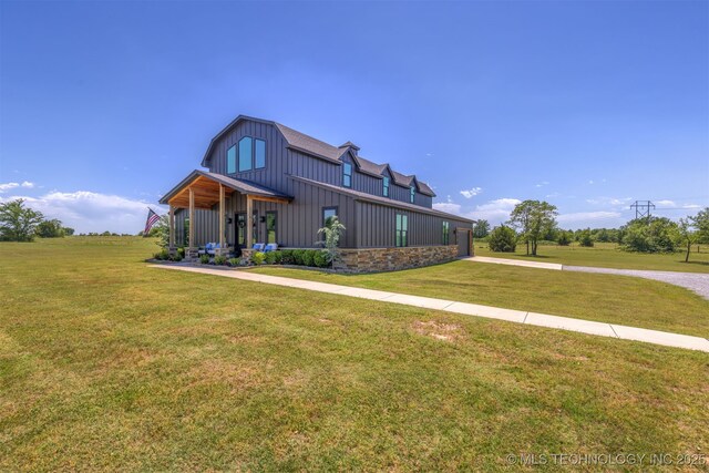 22450 S Rocky Ridge Ln, Claremore, OK 74019 - view of front of home featuring board and batten siding, a front yard, and a gambrel roof