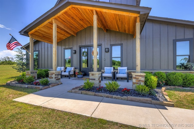 22450 S Rocky Ridge Ln, Claremore, OK 74019 - view of exterior entry featuring covered porch, board and batten siding, and a yard