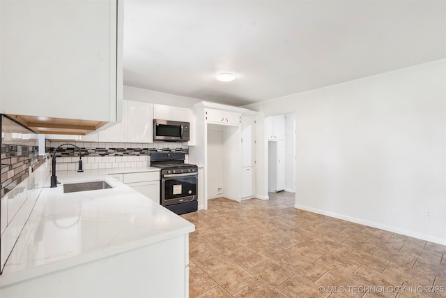 212 W 17th St, Owasso, OK 74055 - kitchen featuring white cabinets, light stone counters, a sink, backsplash, and stainless steel appliances
