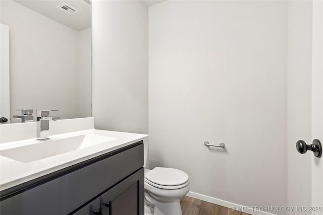 13119 S 72nd E Pl, Bixby, OK 74008 - half bathroom featuring visible vents, wood finished floors, baseboards, vanity, and toilet
