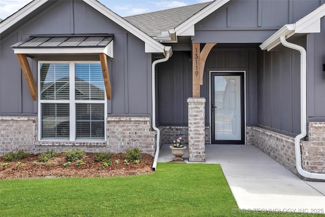13119 S 72nd E Pl, Bixby, OK 74008 - view of exterior entry with a shingled roof, board and batten siding, and a yard