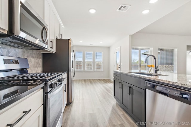 13119 S 72nd E Pl, Bixby, OK 74008 - kitchen featuring visible vents, decorative backsplash, light stone counters, a sink, and stainless steel appliances