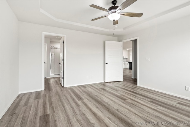 13119 S 72nd E Pl, Bixby, OK 74008 - unfurnished bedroom featuring connected bathroom, ceiling fan, baseboards, wood finished floors, and a tray ceiling