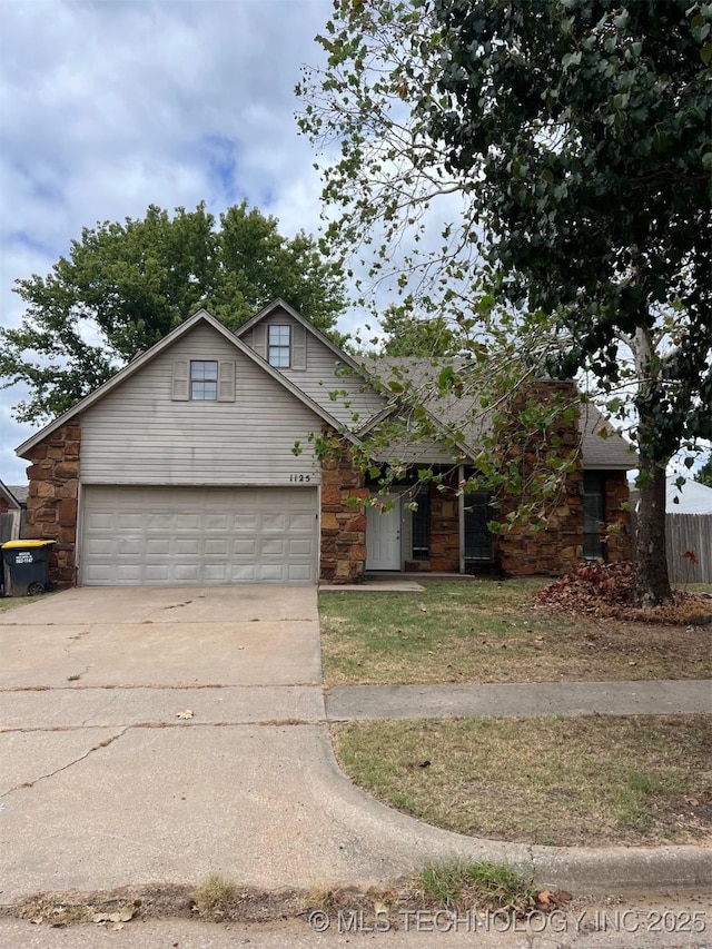 view of front of house featuring stone siding, concrete driveway, and a garage