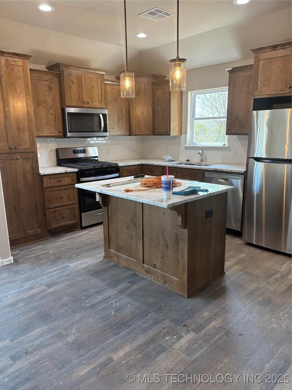 408 S Muskogee St, Sapulpa, OK 74066 - kitchen with appliances with stainless steel finishes, dark wood-type flooring, tasteful backsplash, a kitchen island, and recessed lighting