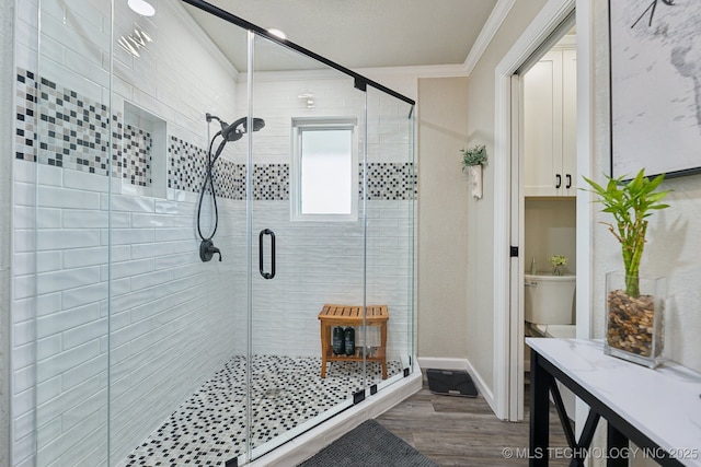 8700 S Union Ave, Tulsa, OK 74132 - bathroom with a stall shower, baseboards, crown molding, and wood finished floors