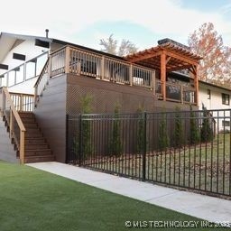 8700 S Union Ave, Tulsa, OK 74132 - view of gate featuring fence and stairway