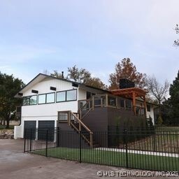 8700 S Union Ave, Tulsa, OK 74132 - view of front of home featuring a garage, concrete driveway, a fenced front yard, and stairs