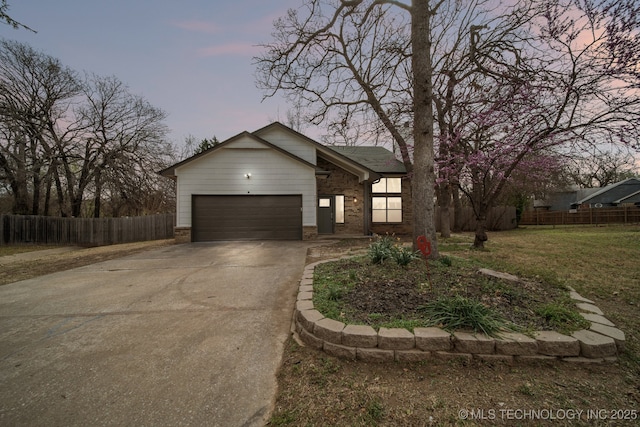 view of front of property with fence, a front yard, brick siding, concrete driveway, and an attached garage