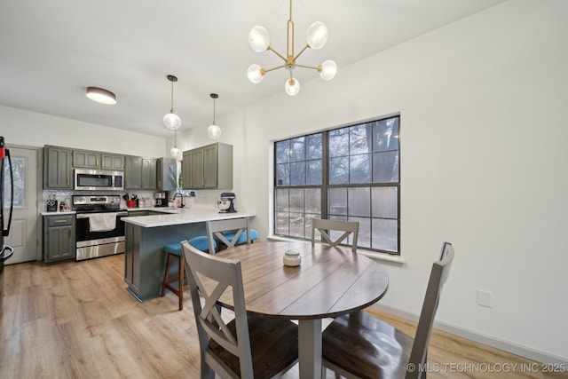 dining room featuring light wood-style floors and a notable chandelier