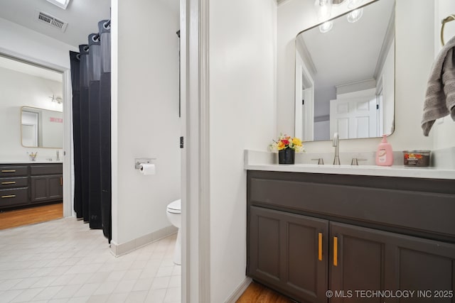 bathroom featuring visible vents, tile patterned flooring, vanity, baseboards, and toilet